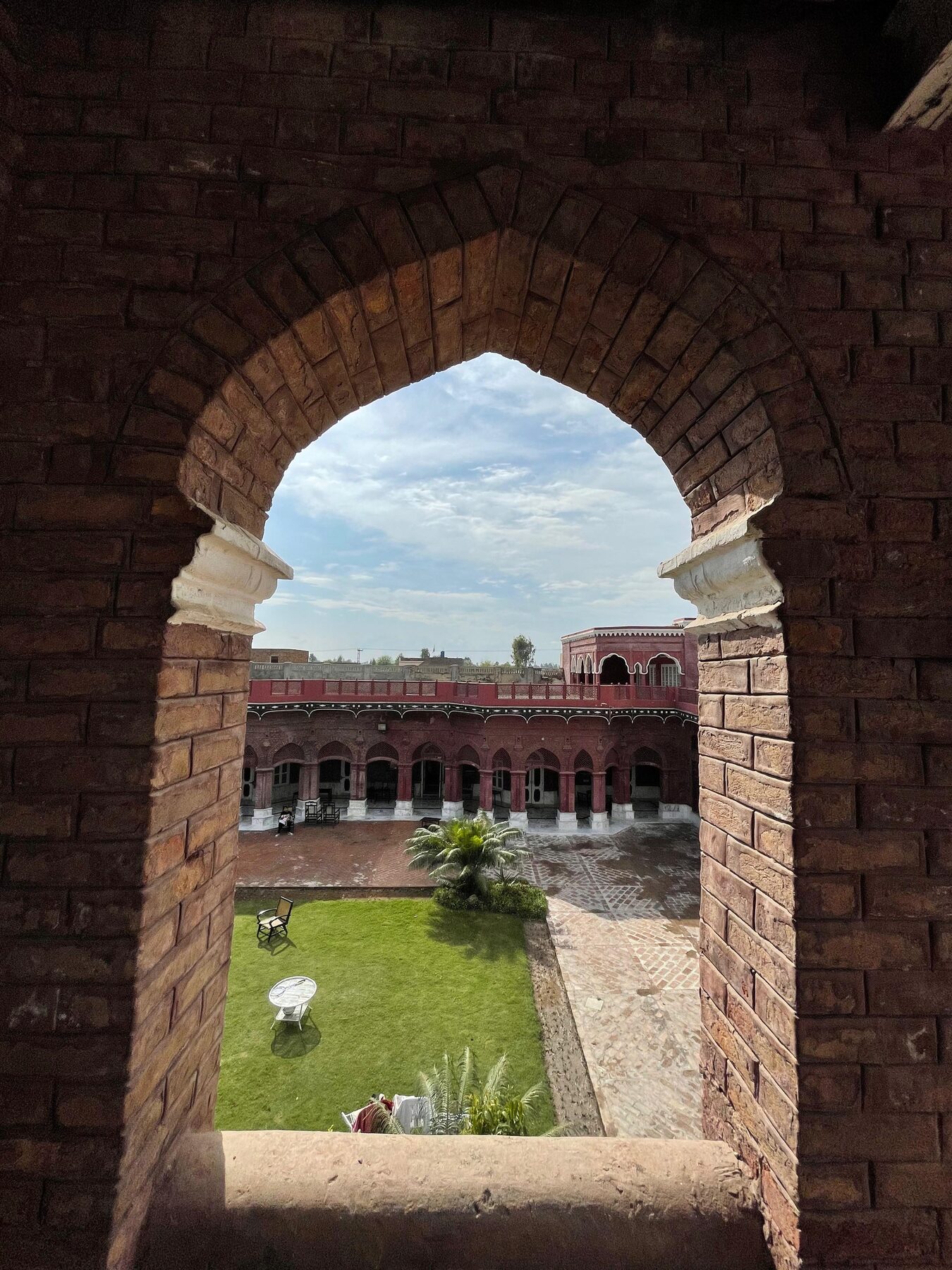 View through a brick archway onto the courtyard