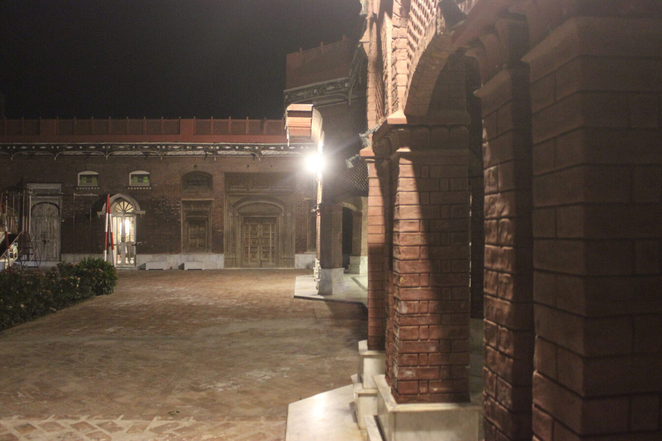 Wide courtyard walkway lit at night