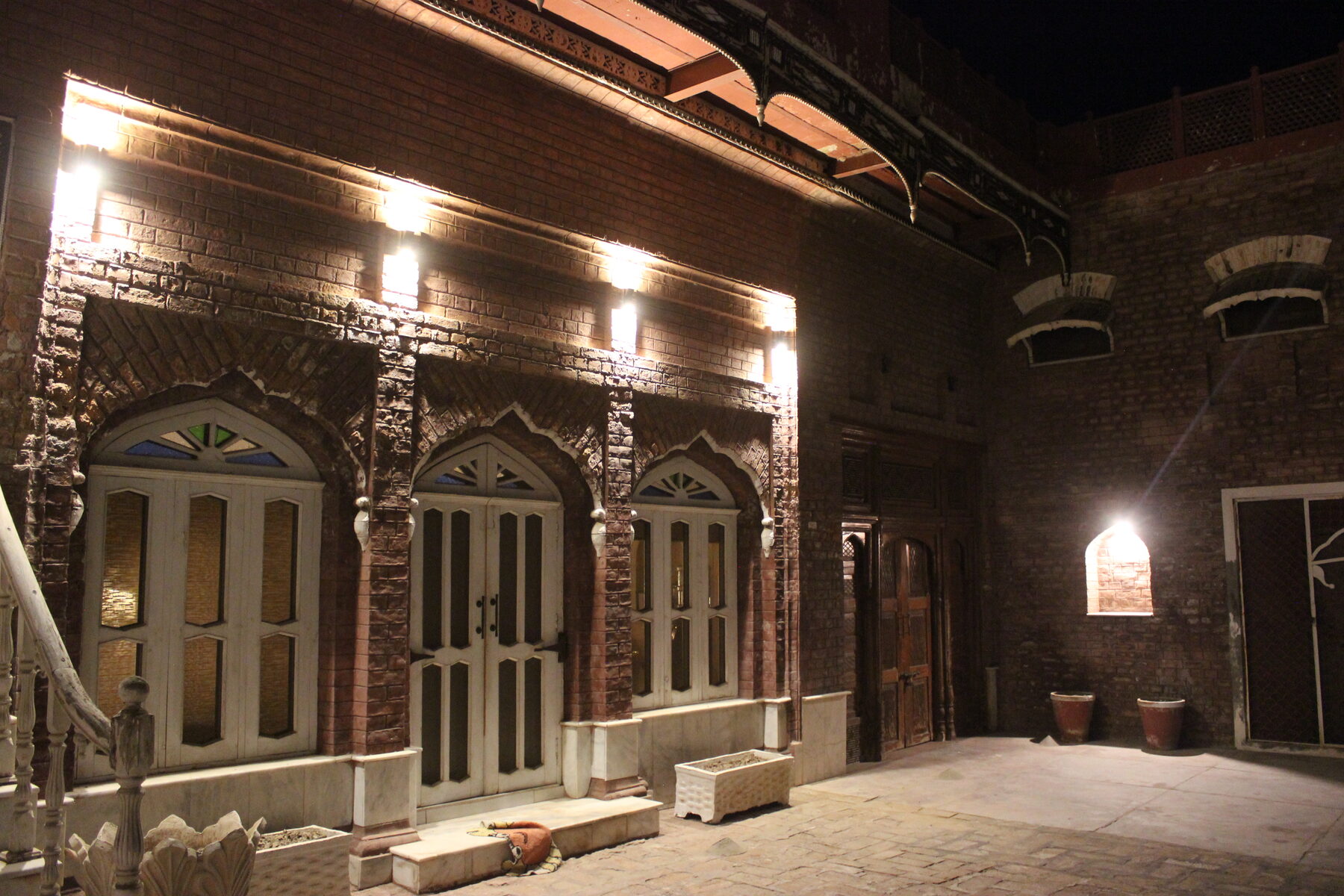 Stained-glass doorways along the arcade at night